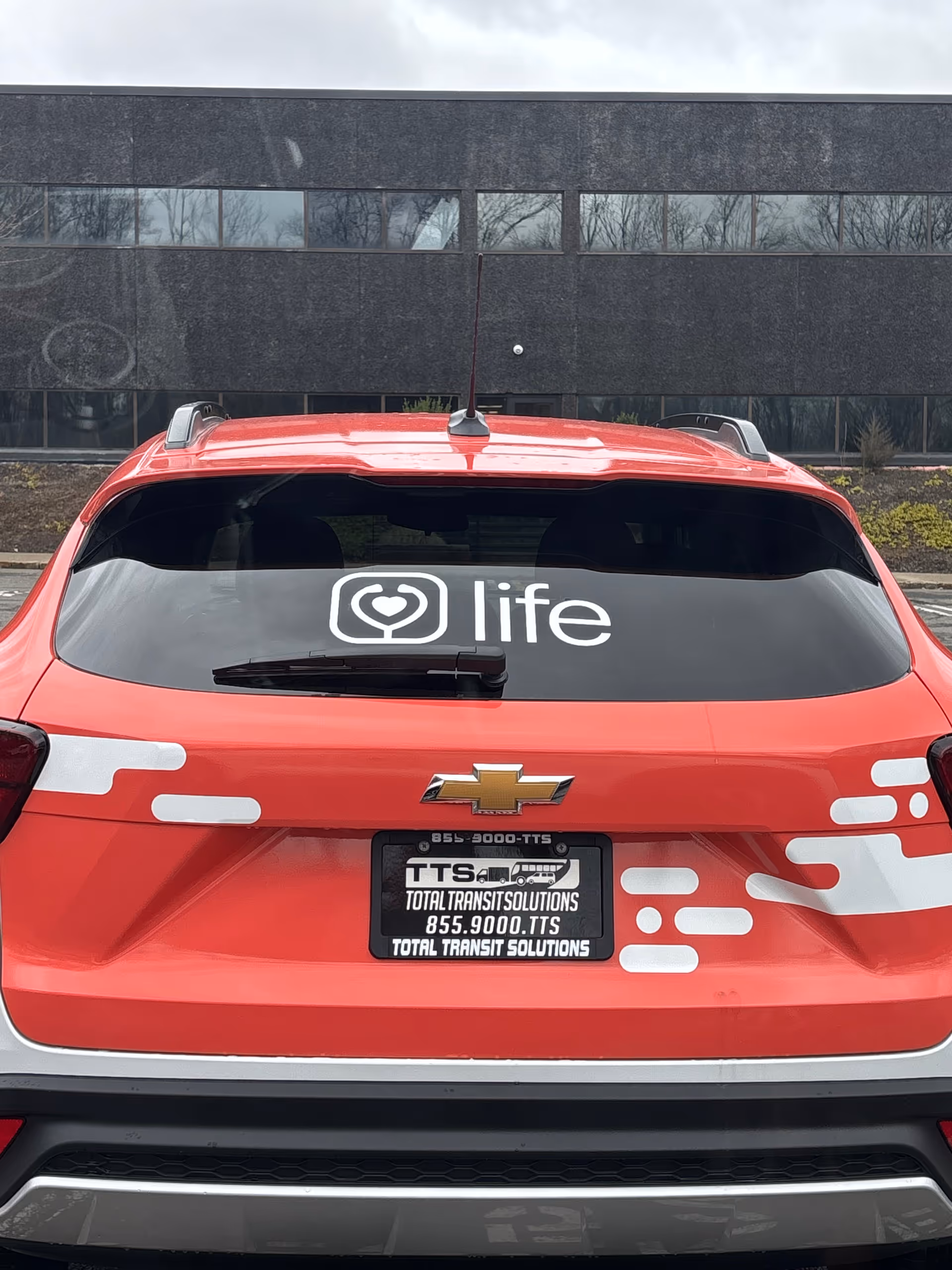 Red Life Medical branded SUV parked outside a dark office building.