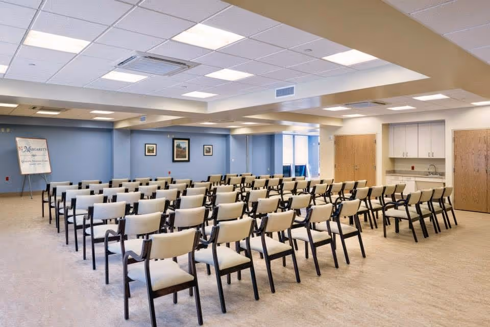 A large indoor room with many beige chairs arranged in rows.