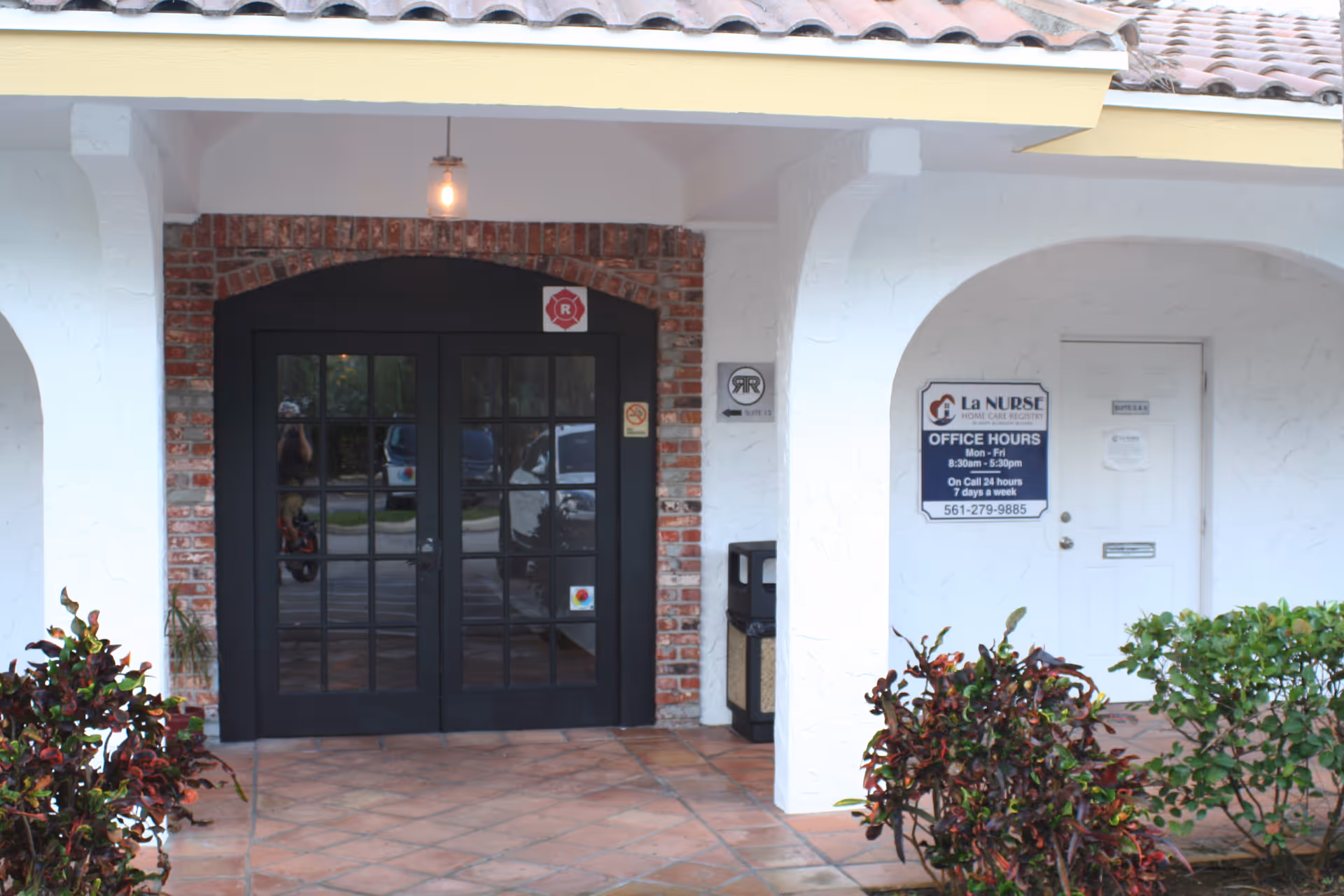 Exterior entrance to La Nurse Home Care Registry with glass doors and brick archway.