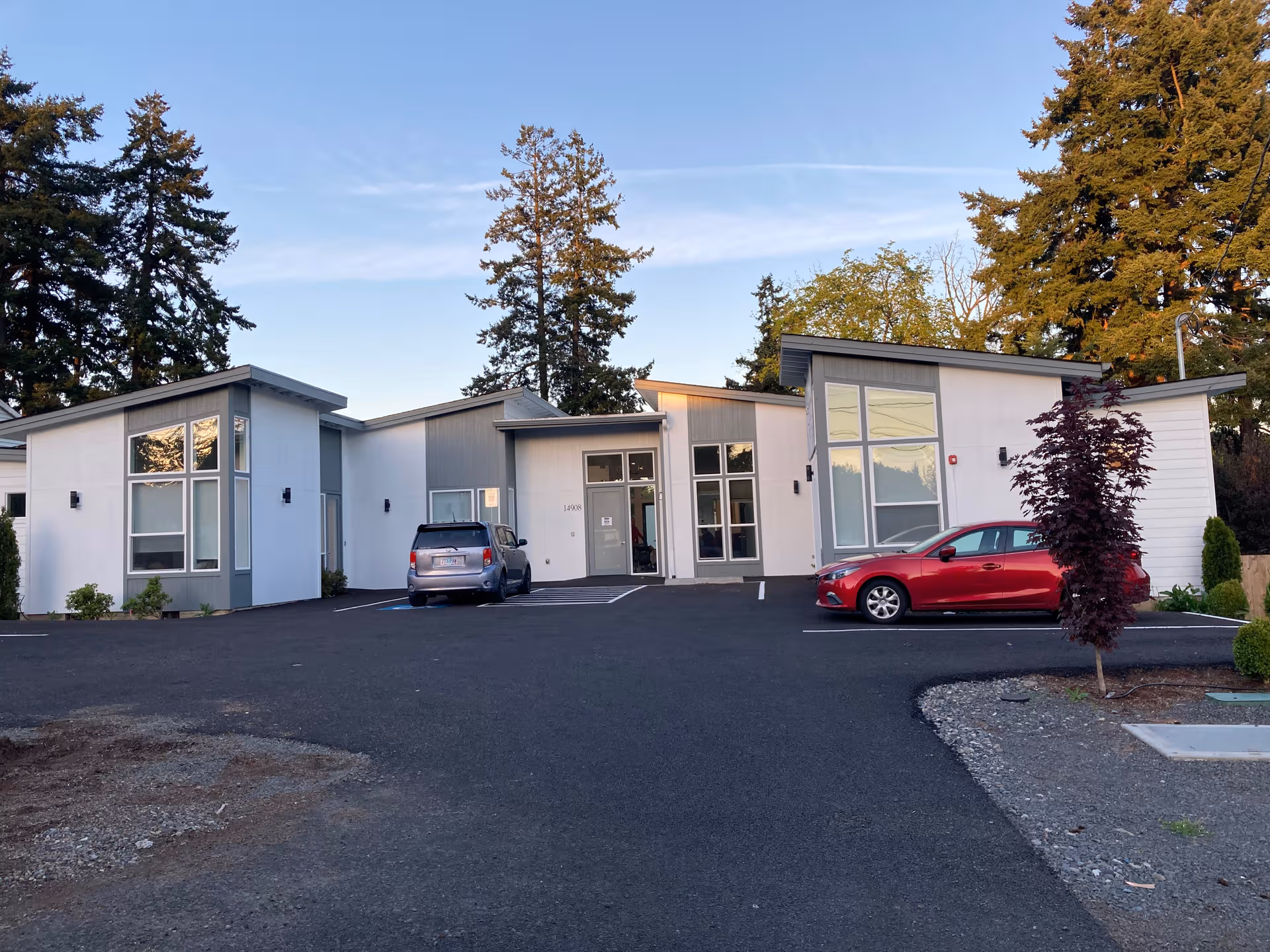 Modern, single-story Cedar Senior Living building with parking lot and surrounding trees.