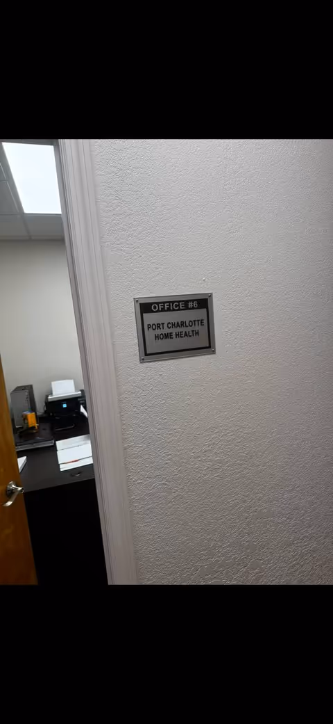 Office hallway with an open door to a desk and sign reading Port Charlotte Home Health.