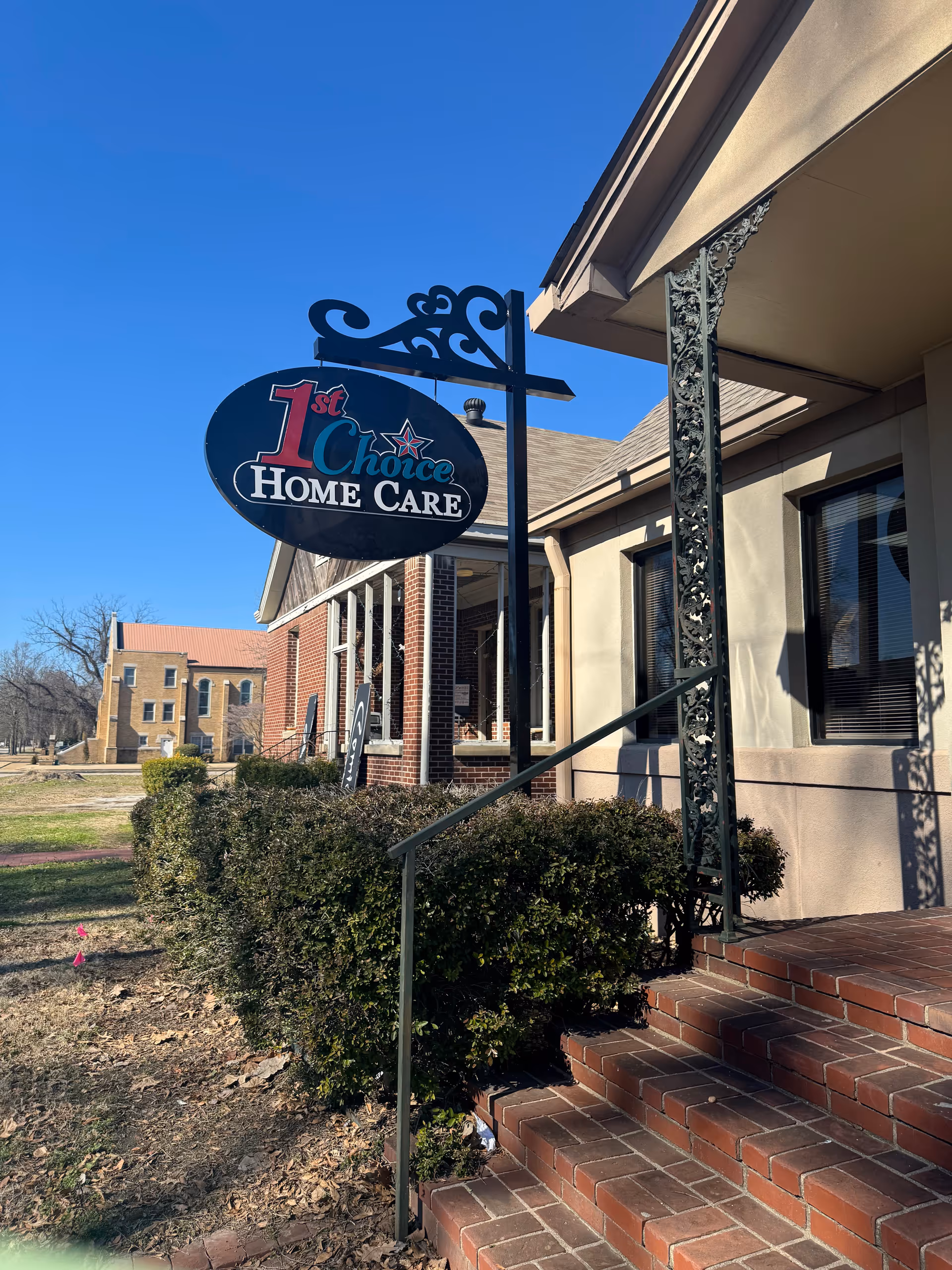 Exterior view of a facility entrance with a hanging 1st Choice Home Care sign.