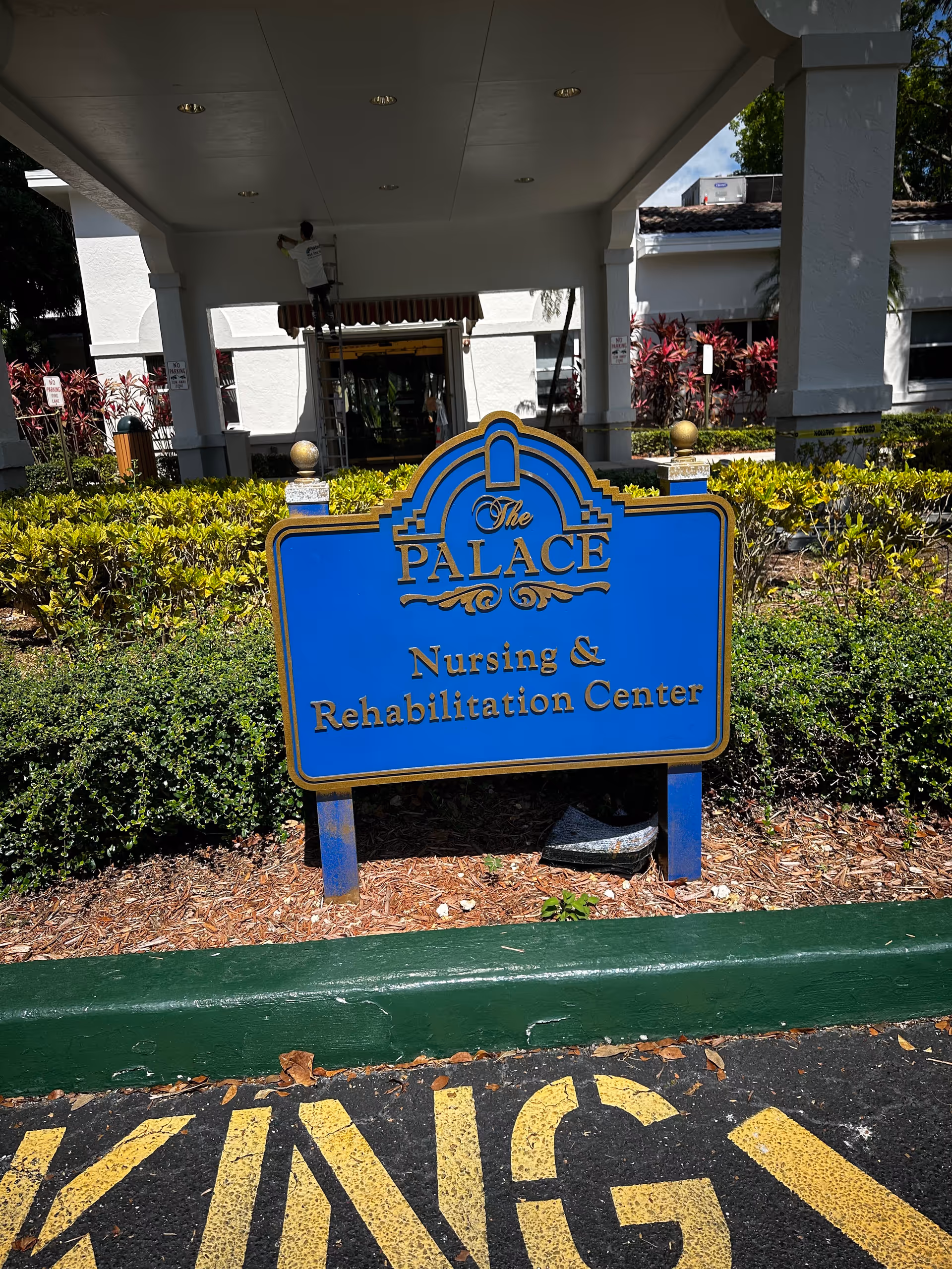 The Palace Nursing and Rehabilitation Center entrance with a large blue sign.