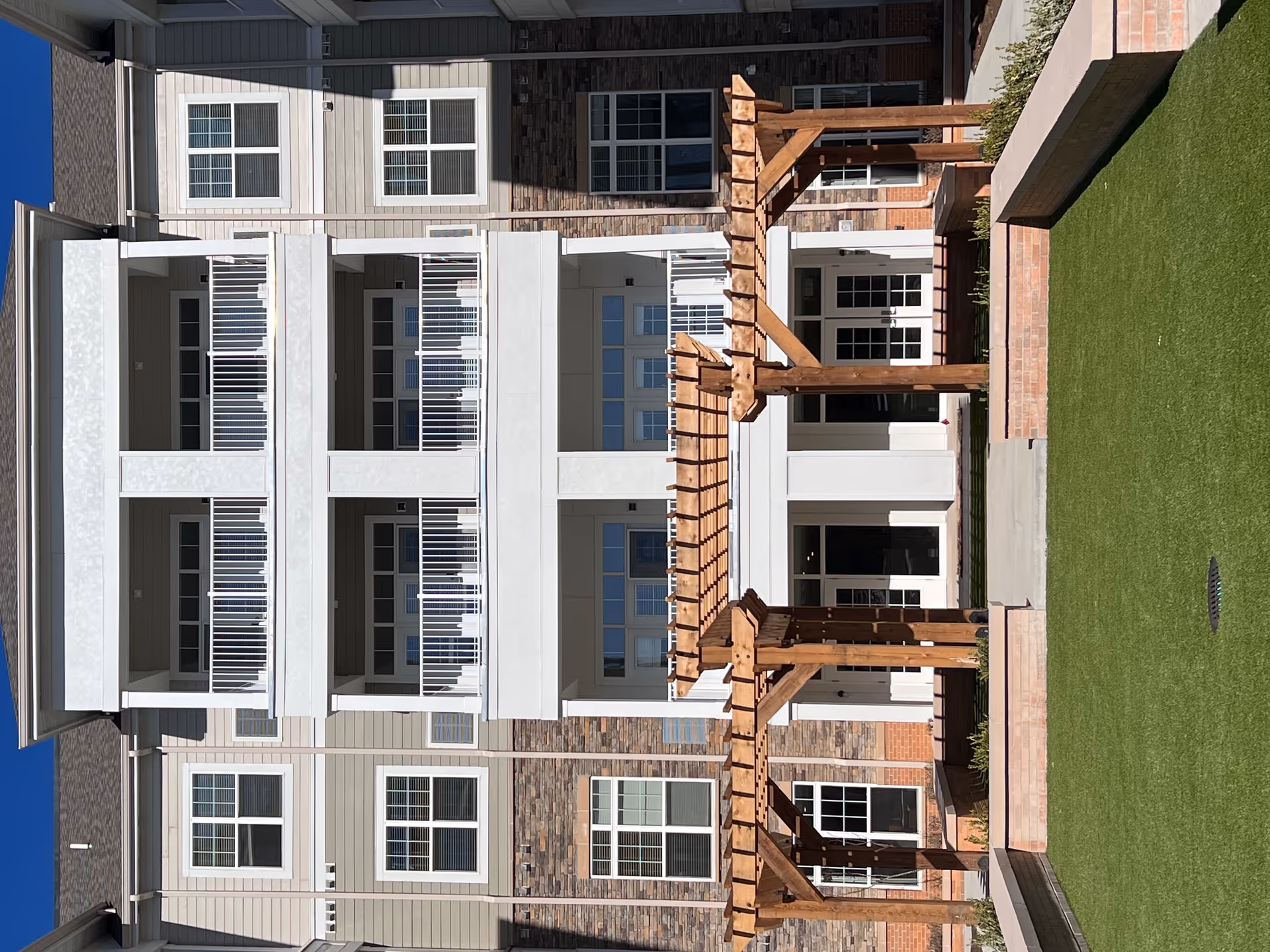 Exterior view of The Lumiere of Chesterfield with balconies, brick facade, and wooden pergola.