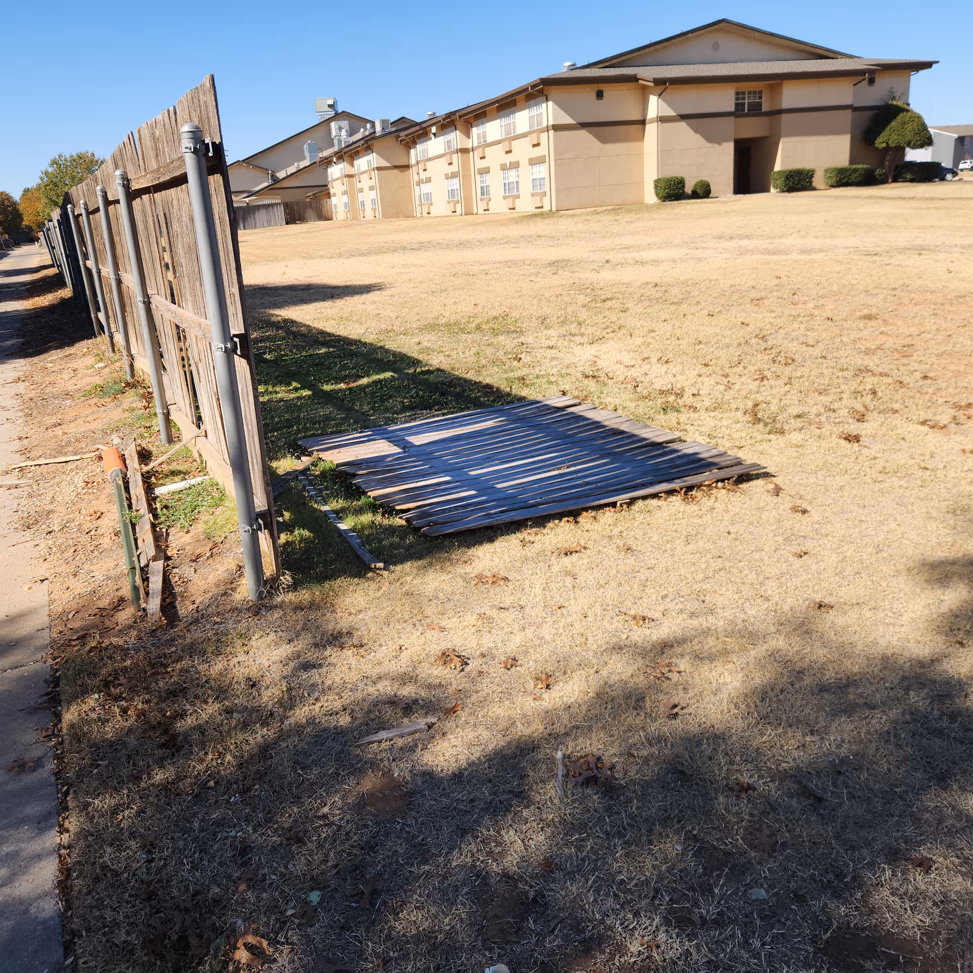 Exterior view of Brookdale Remington Park building with a wooden fence and yard.