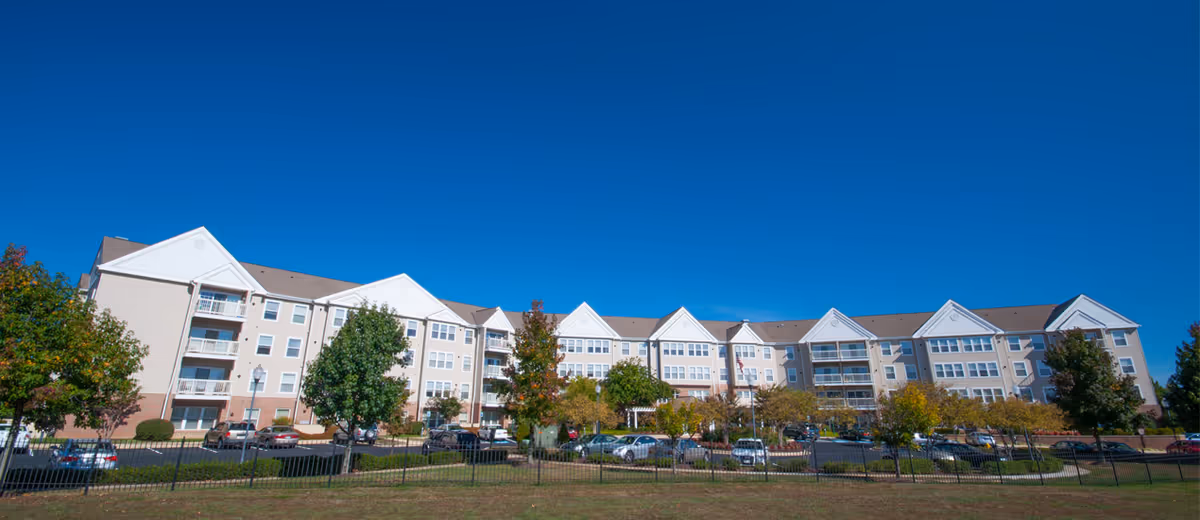 Exterior view of Parker-Hall House senior living building with cars in parking lot.