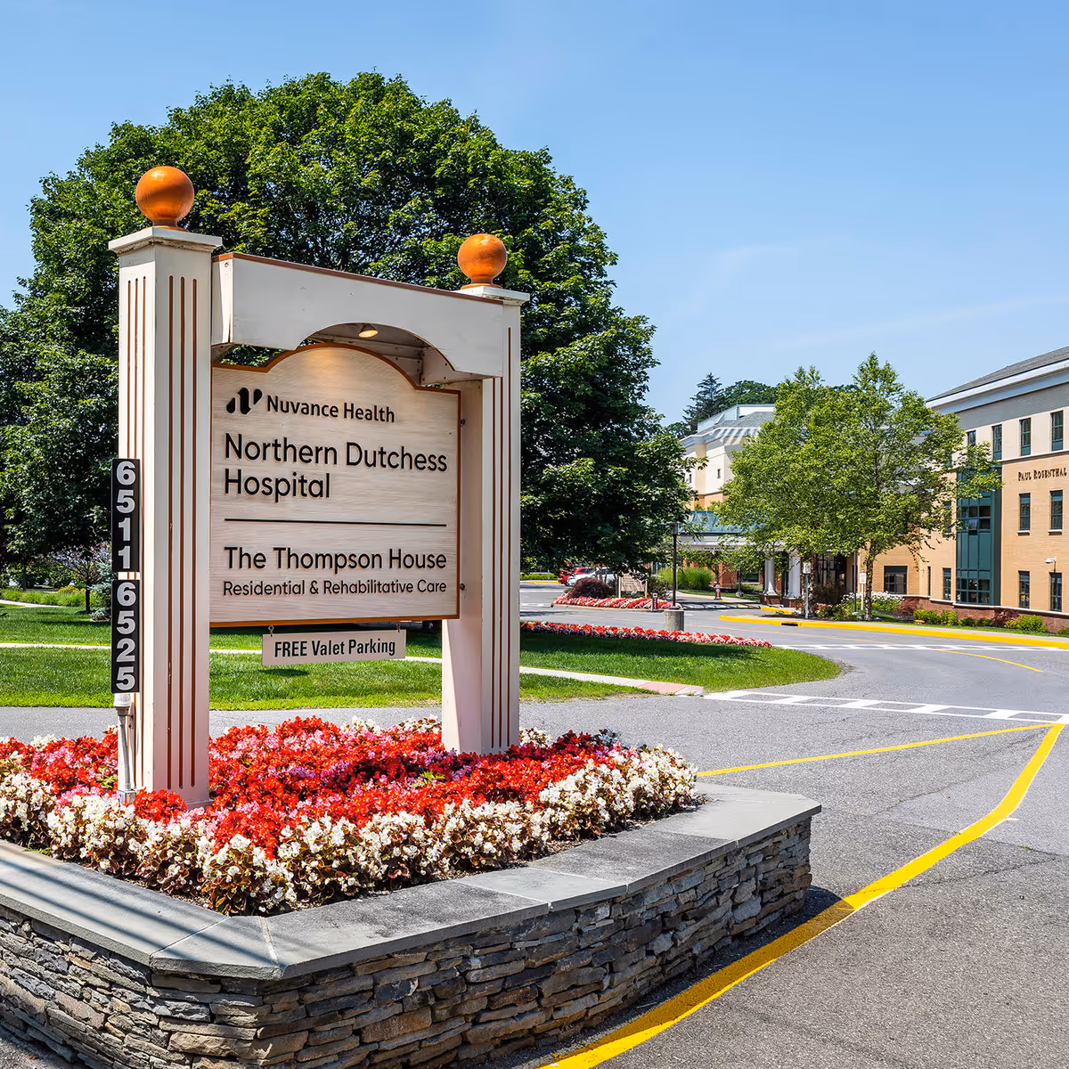 Outdoor hospital sign with landscaping and building facade in background