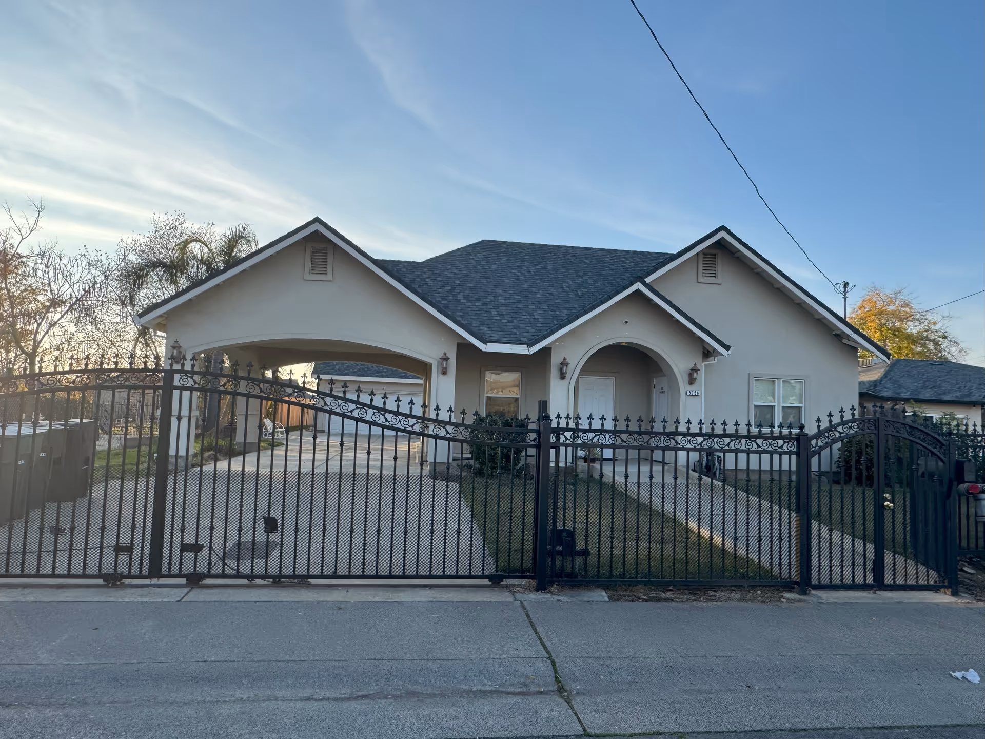 Front view of a single-story assisted living facility with a gated entrance.