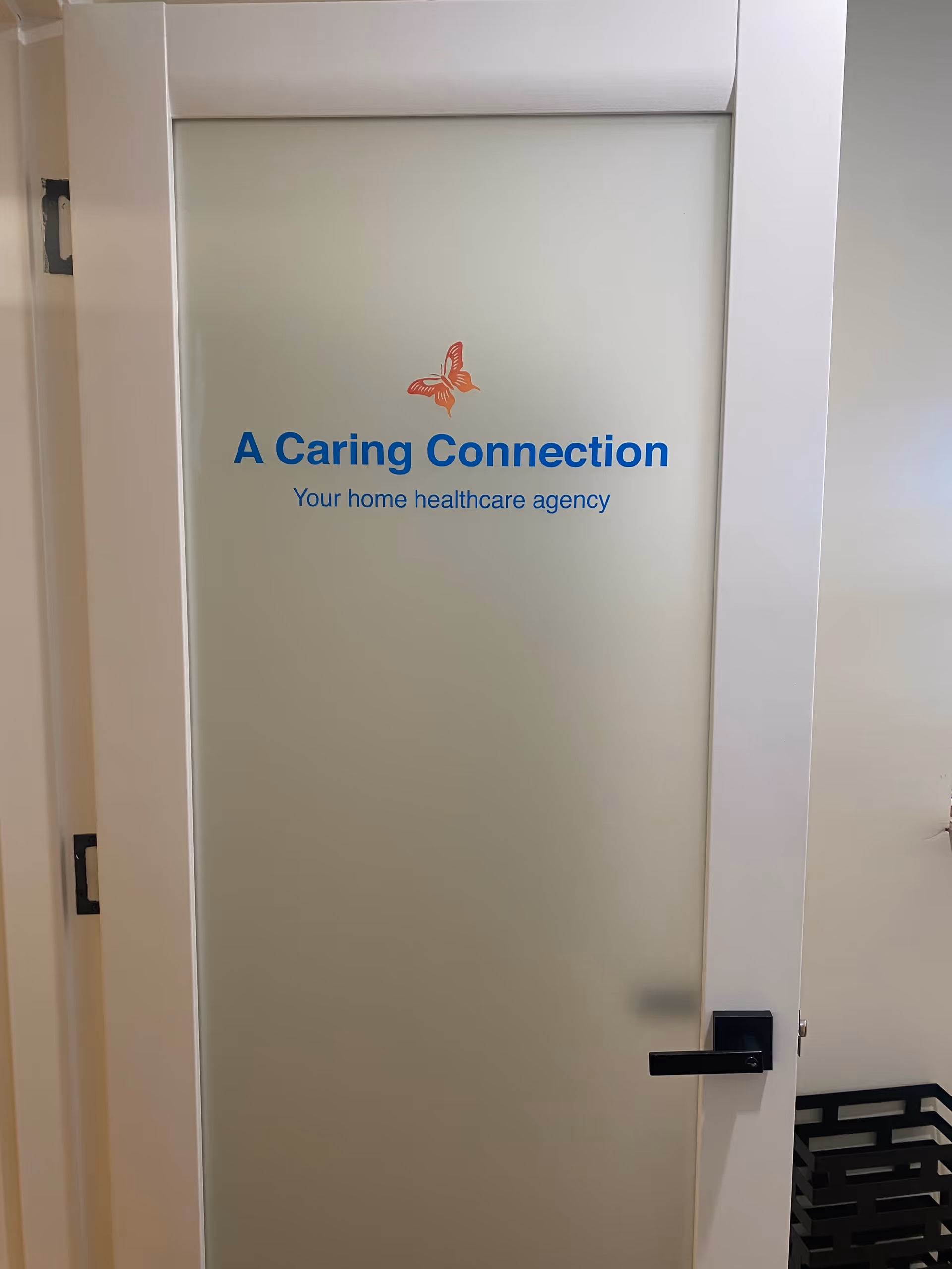 Frosted glass door bearing A Caring Connection logo and 'Your home healthcare agency' text.