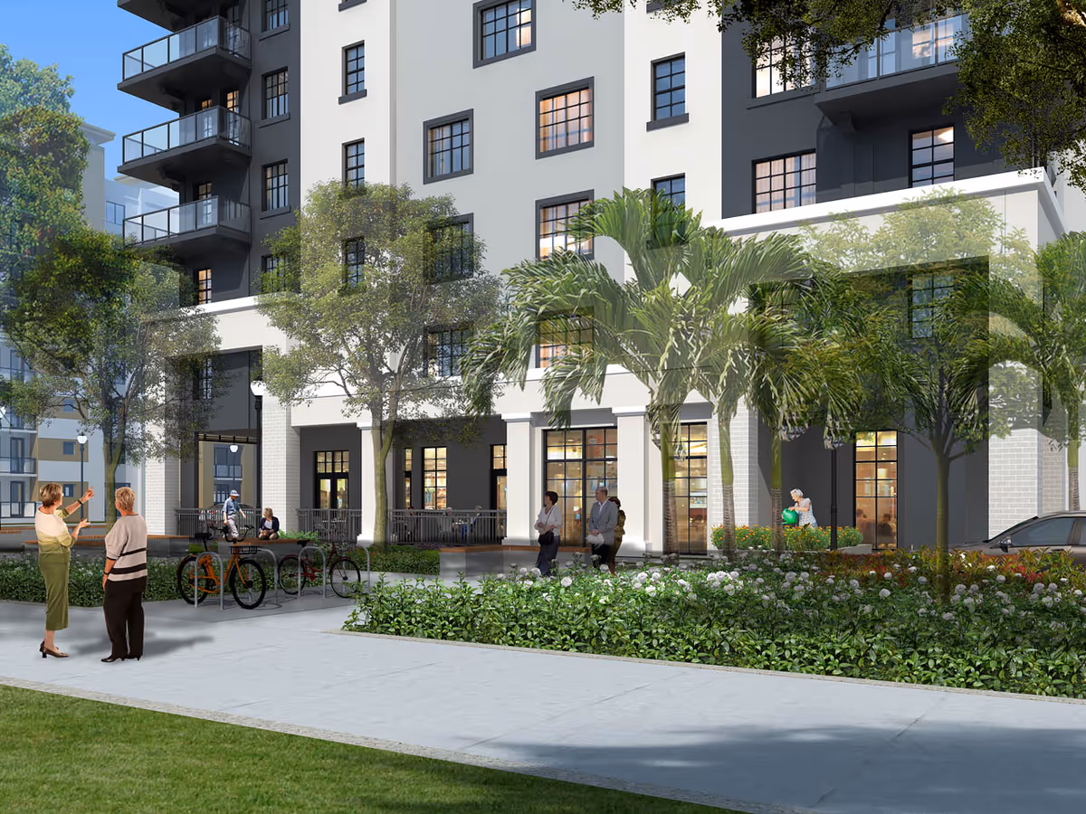 Modern multi-story senior living building exterior with trees, walkway, and residents outdoors.
