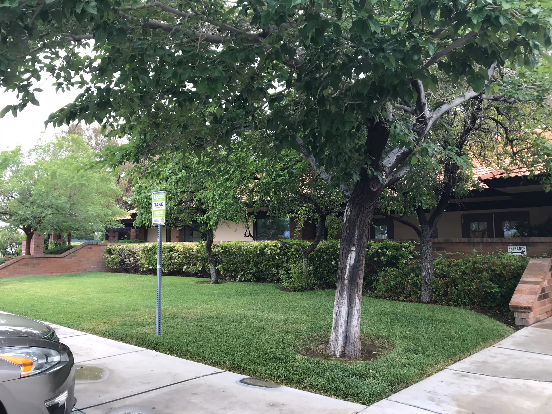 Exterior view of the Nathan Adelson Hospice building with trees, shrubs, and entrance walkway.