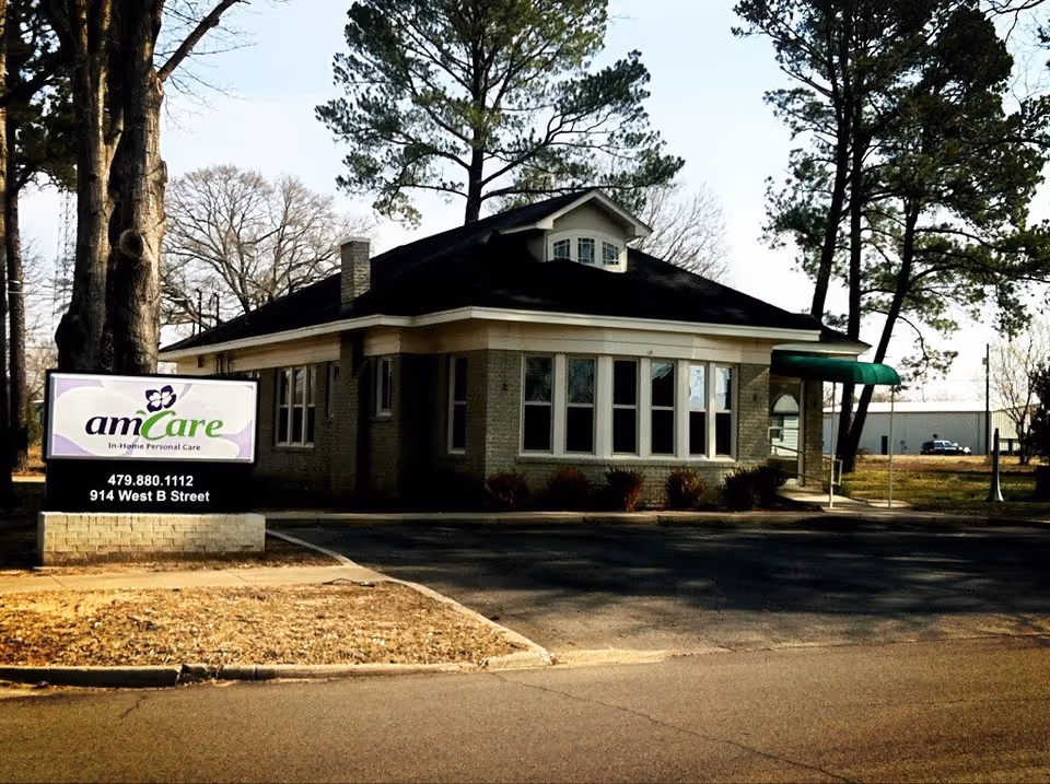 Exterior view of AmCare Senior Life Partners facility with sign and entrance.