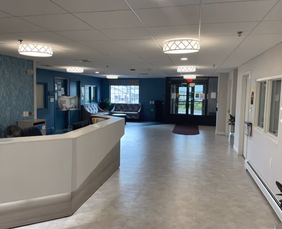 Interior lobby of a senior living center with reception desk and seating.