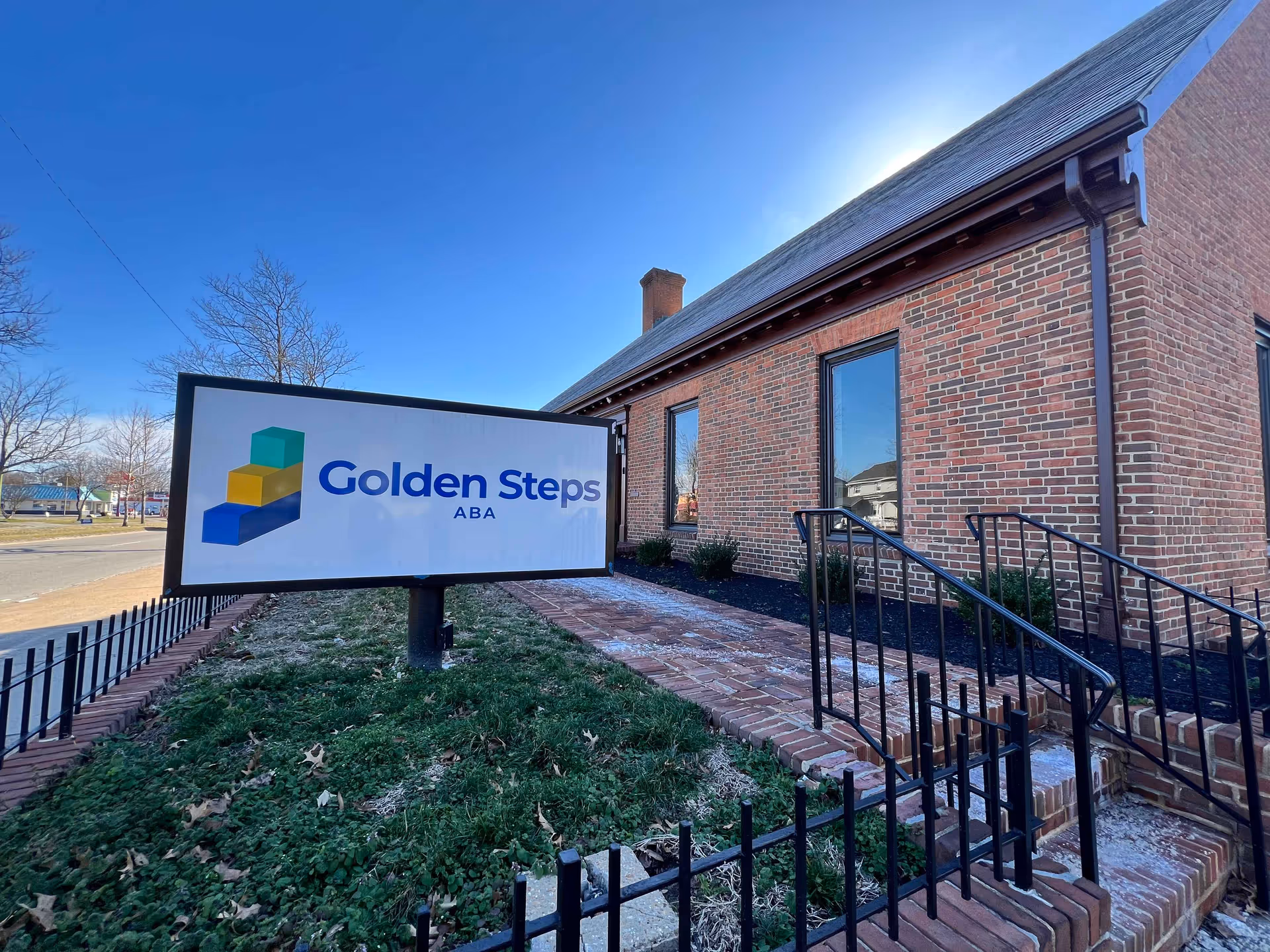 Brick building exterior with a large Golden Steps ABA sign near the entrance