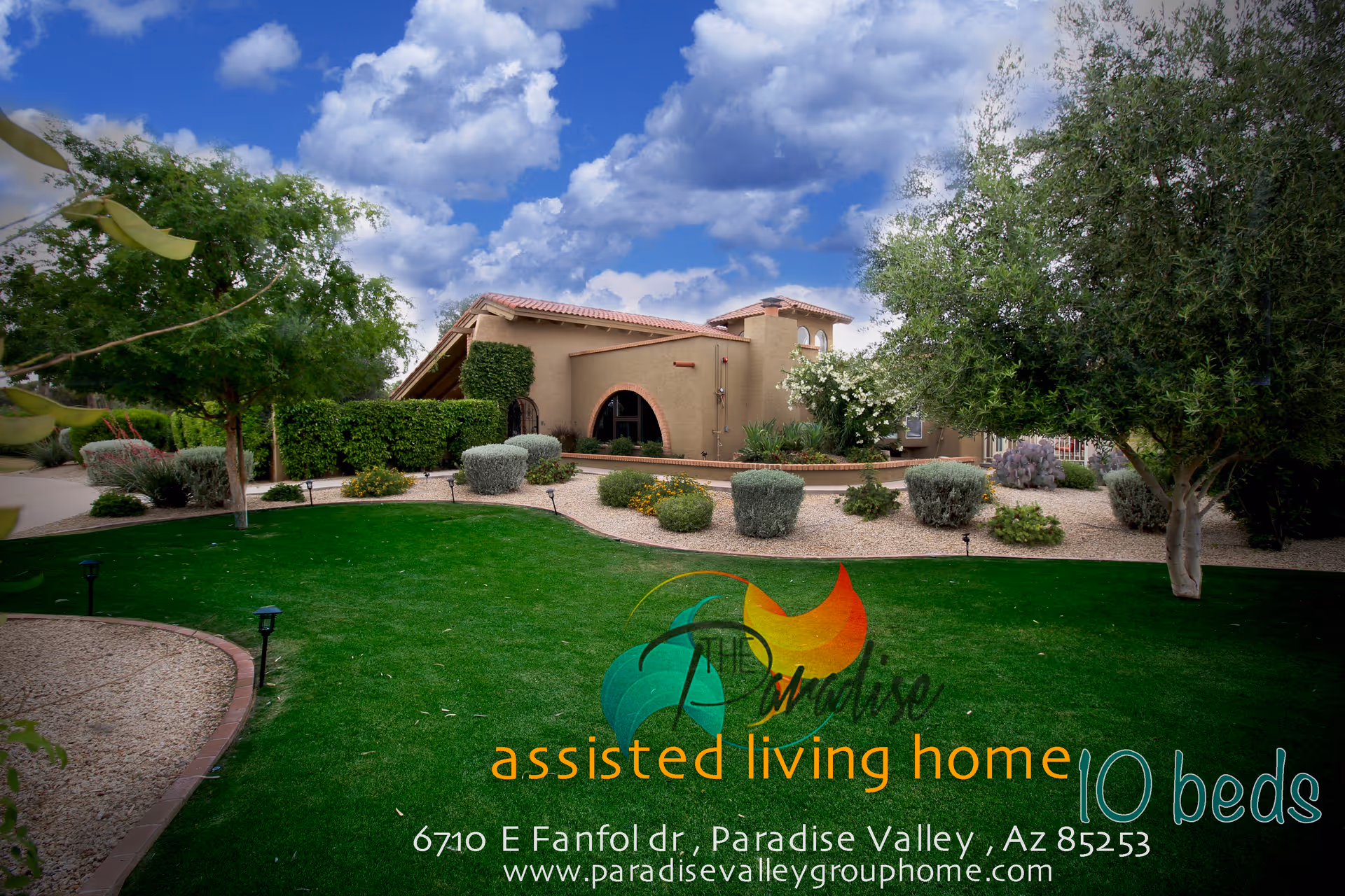 Front exterior of Paradise Assisted Living Home with a lush green lawn and desert landscaping.