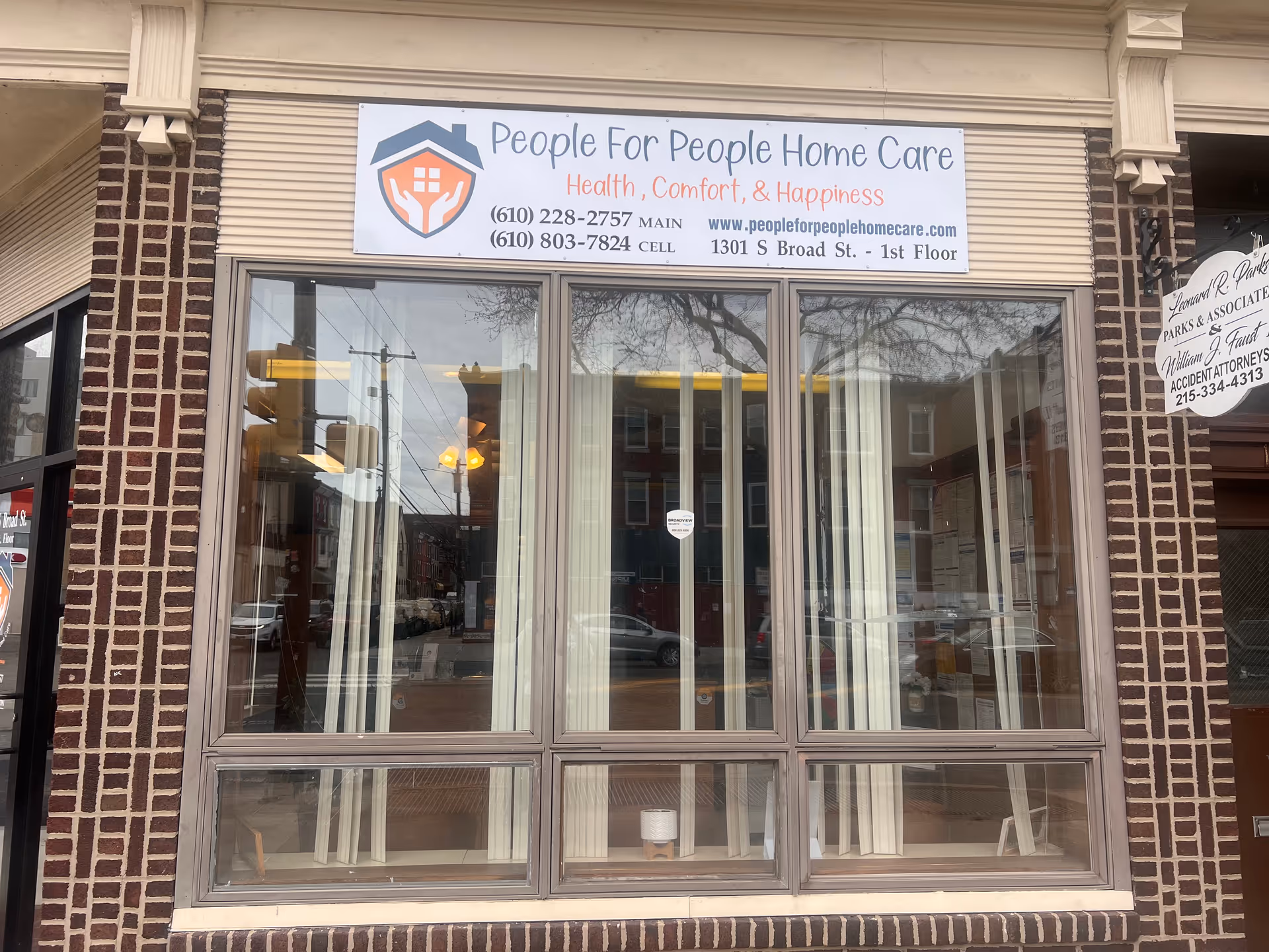 Storefront with large windows and a sign for 'People For People Home Care'.