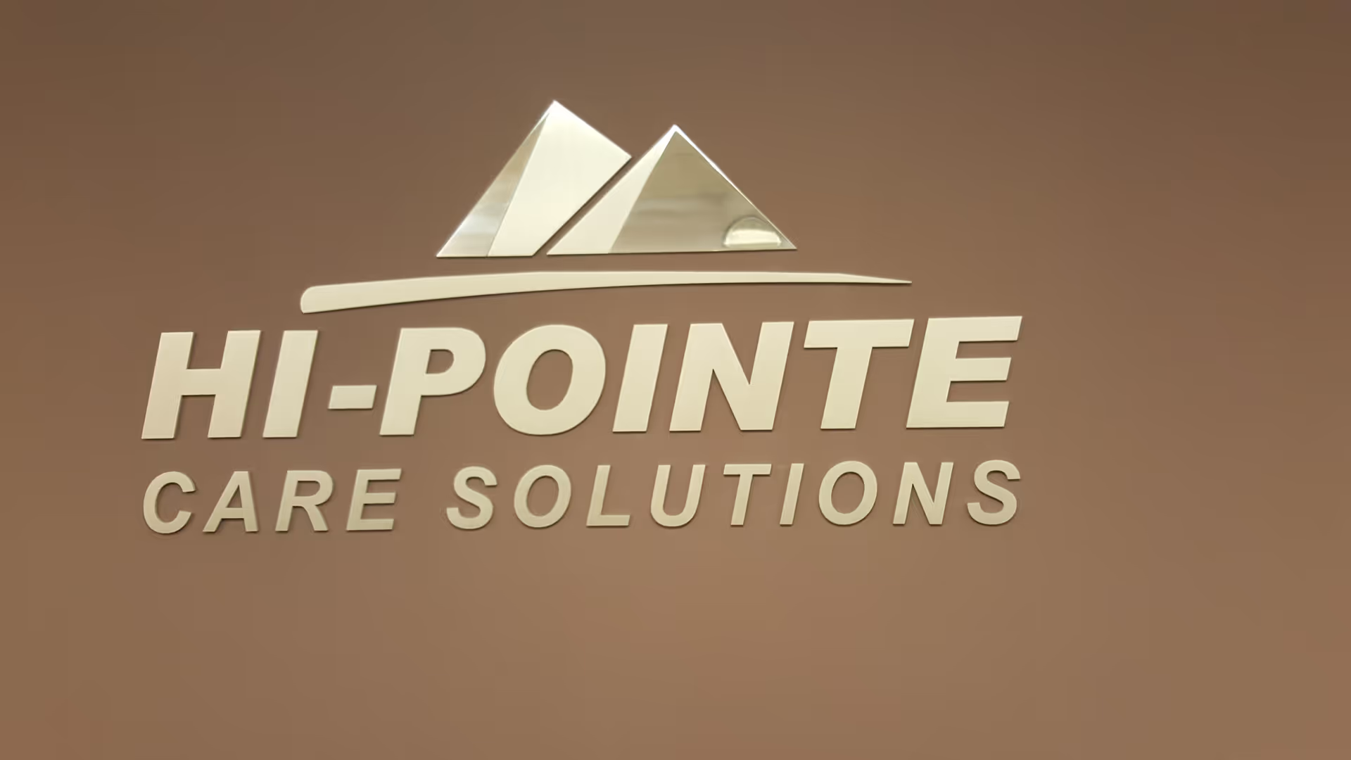 Interior brown wall featuring HI-POINTE CARE SOLUTIONS sign and logo