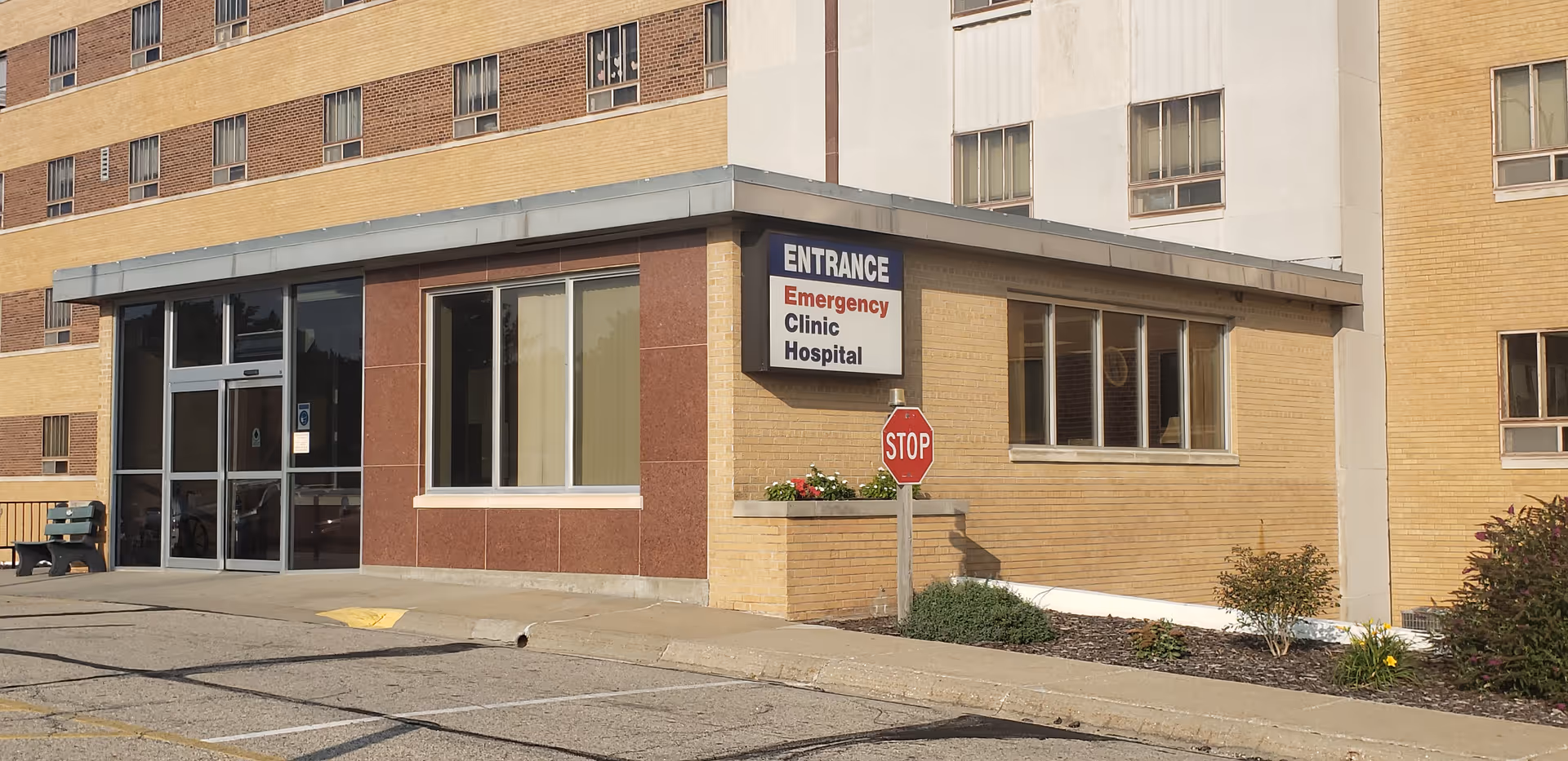 Exterior entrance of a medical center with Stop sign and adjacent parking.