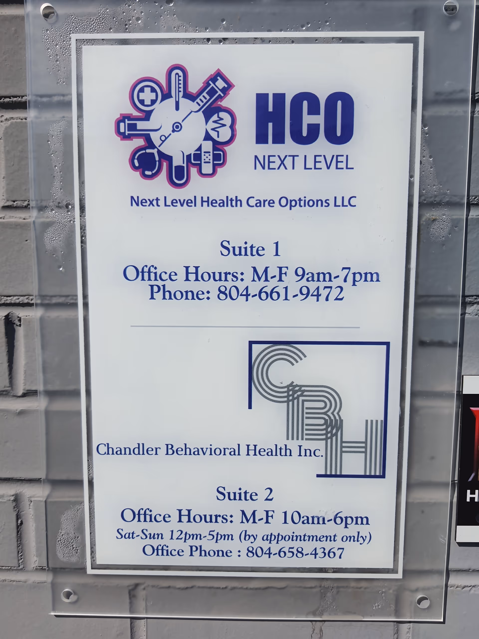 Exterior sign on a brick wall advertising Next Level Health Care Options LLC and suites