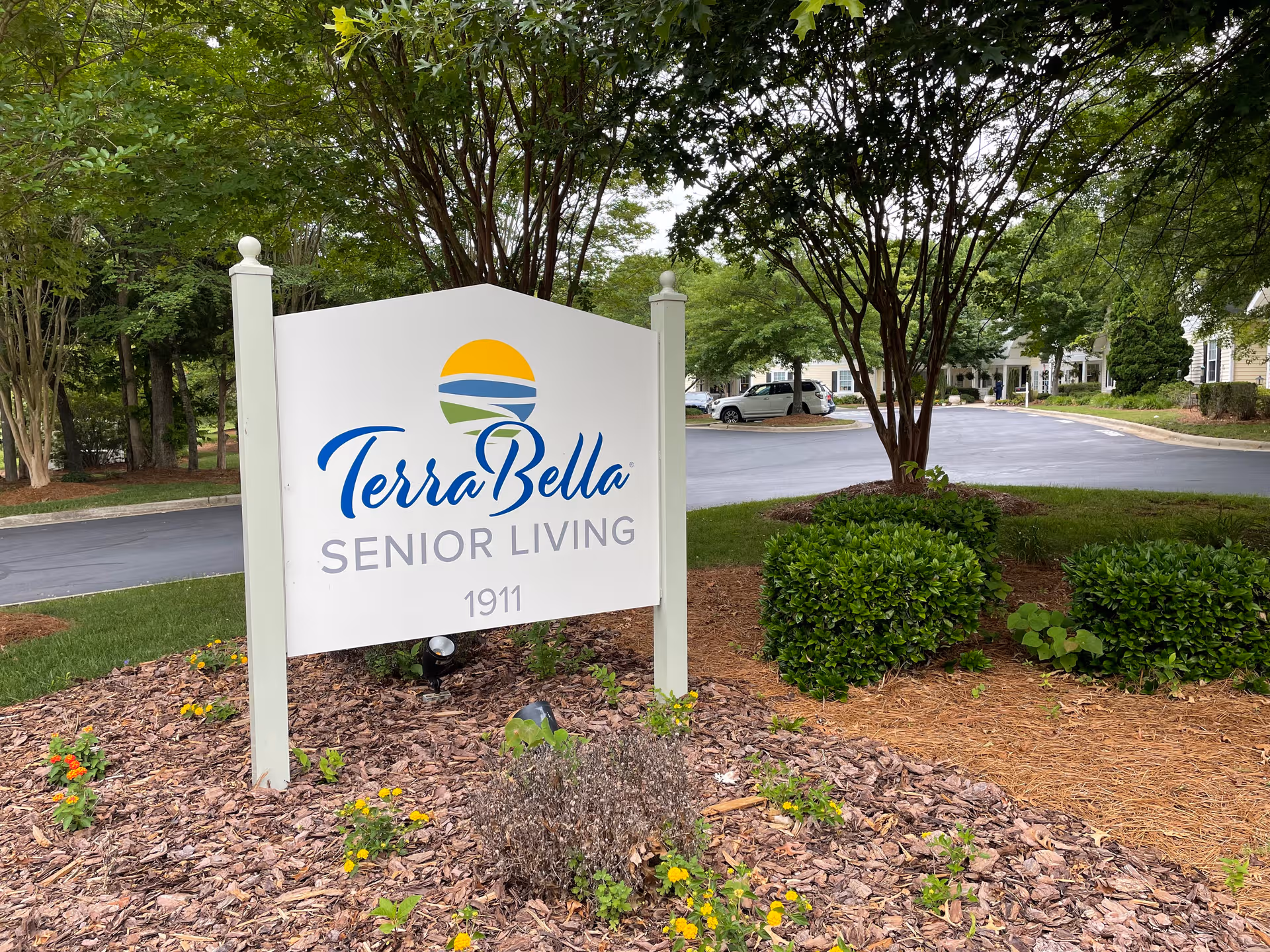 TerraBella Senior Living sign in a landscaped outdoor entrance with trees