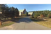 Driveway leads to Bedford Hills Center's front exterior, framed by trees.
