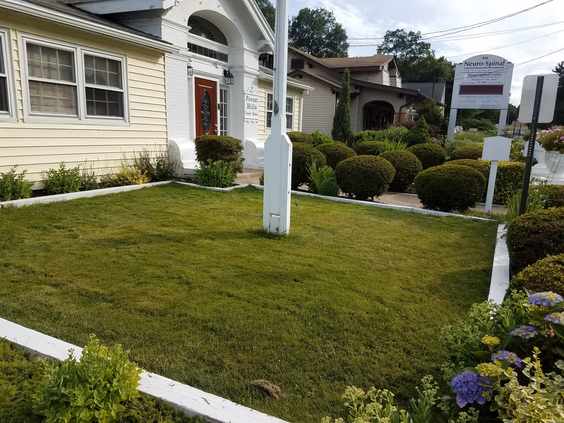 Front view of Forest Hills Guest Home with manicured lawn and shrubs.