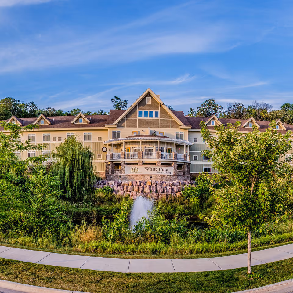 Exterior view of Cottage Grove White Pine Senior Living with landscaped grounds and fountain.