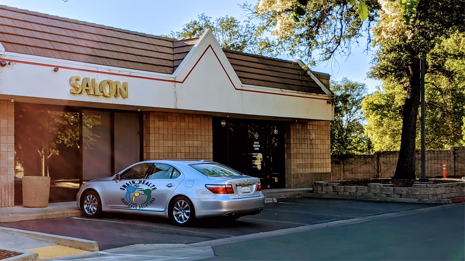 Exterior view of Elite Health Care facility with a parked sedan in front of SALON.