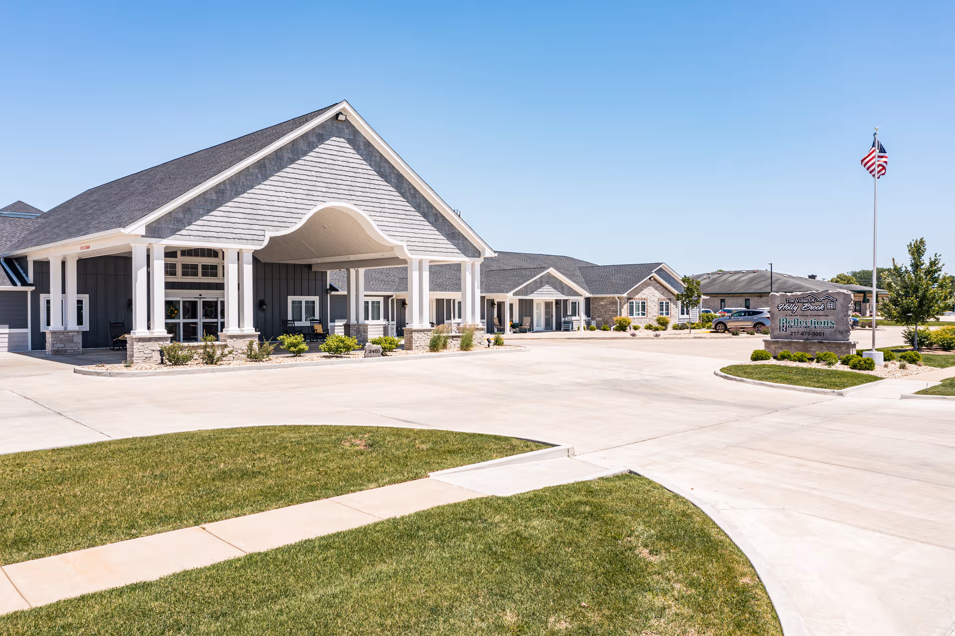Exterior view of Villas of Holly Brook Springfield with curved entry canopy and surrounding parking lot.