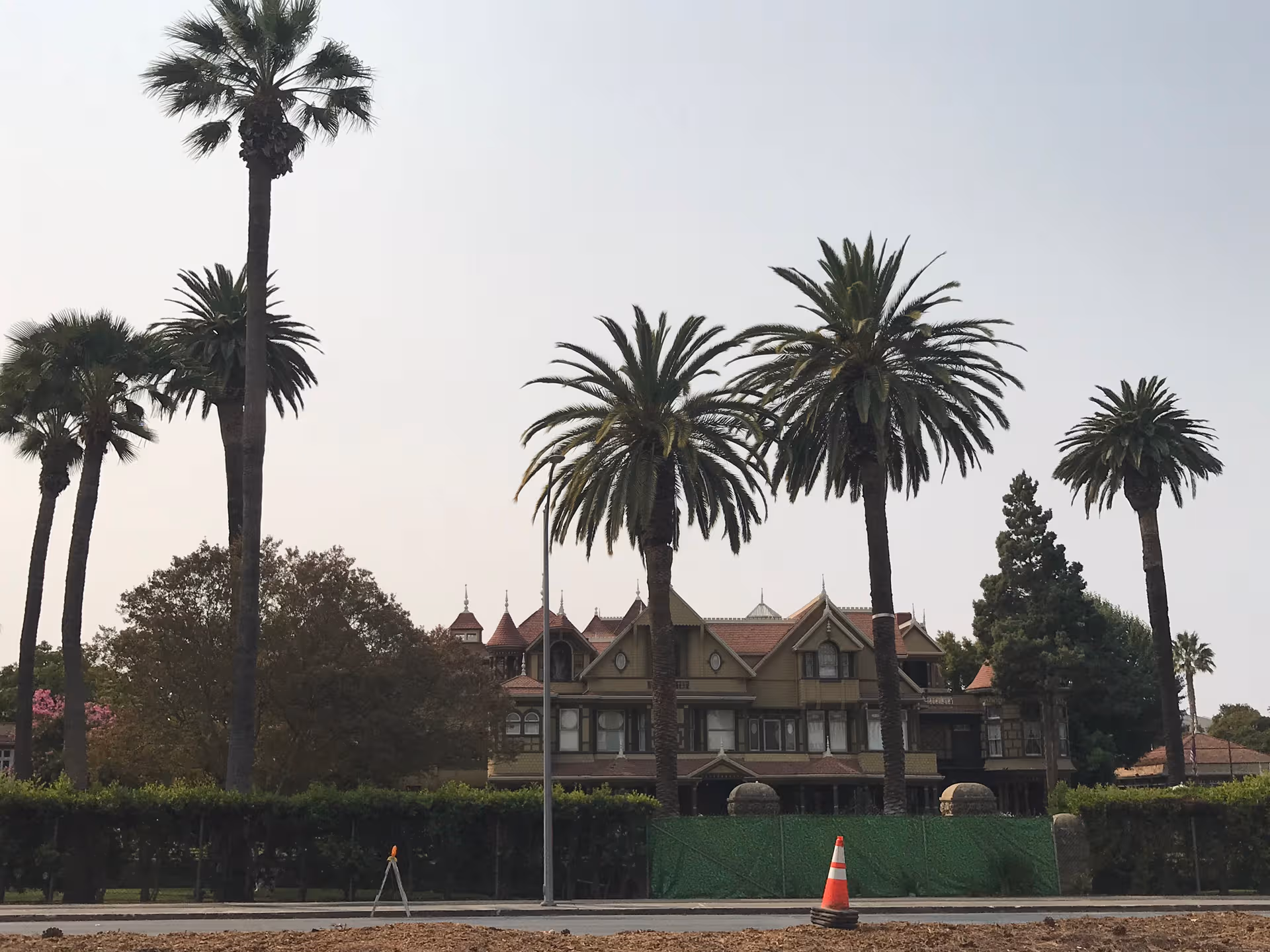 Front exterior of Belmont Village Senior Living San Jose with tall palm trees.