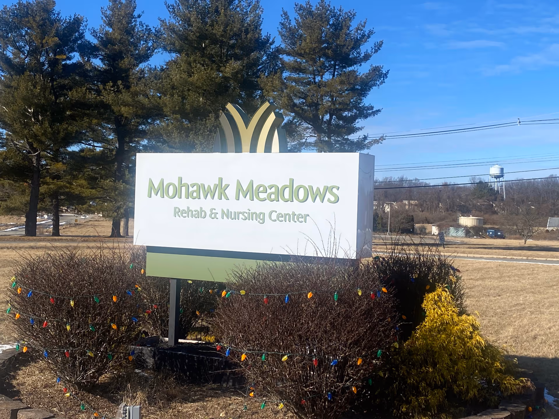 Outdoor sign for Mohawk Meadows Rehab & Nursing Center with holiday lights