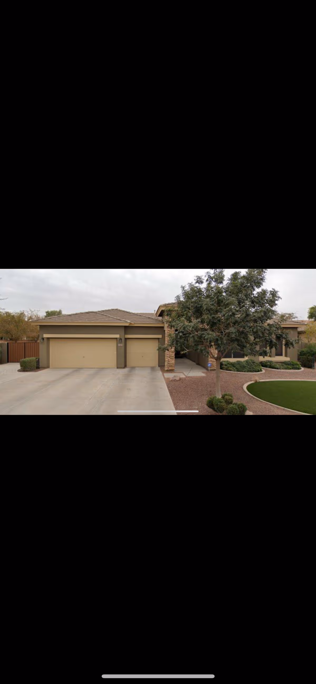Front view of a single-story beige senior living facility with a two-car garage.