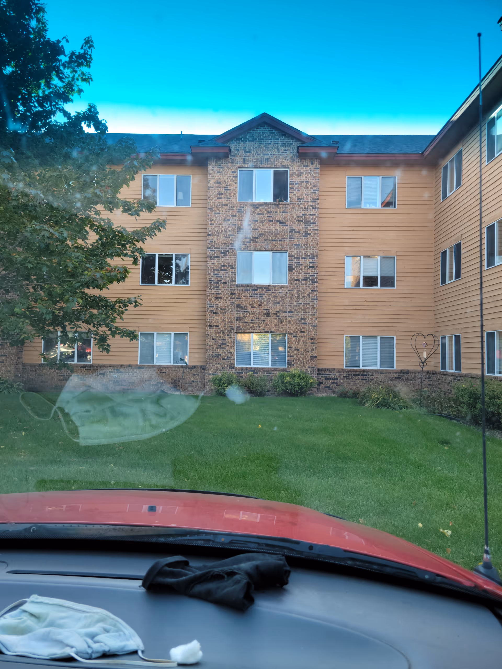 Exterior view of Martin Luther Campus building facade with windows and green lawn, from car