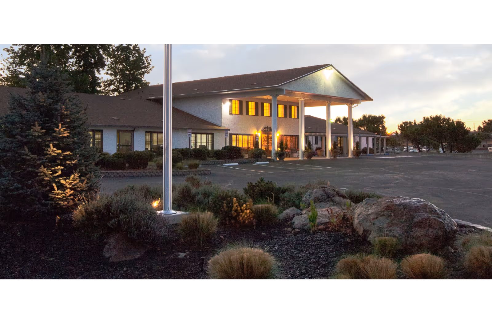 Front exterior view of Westview Healthcare Center with lit entrance and columns.