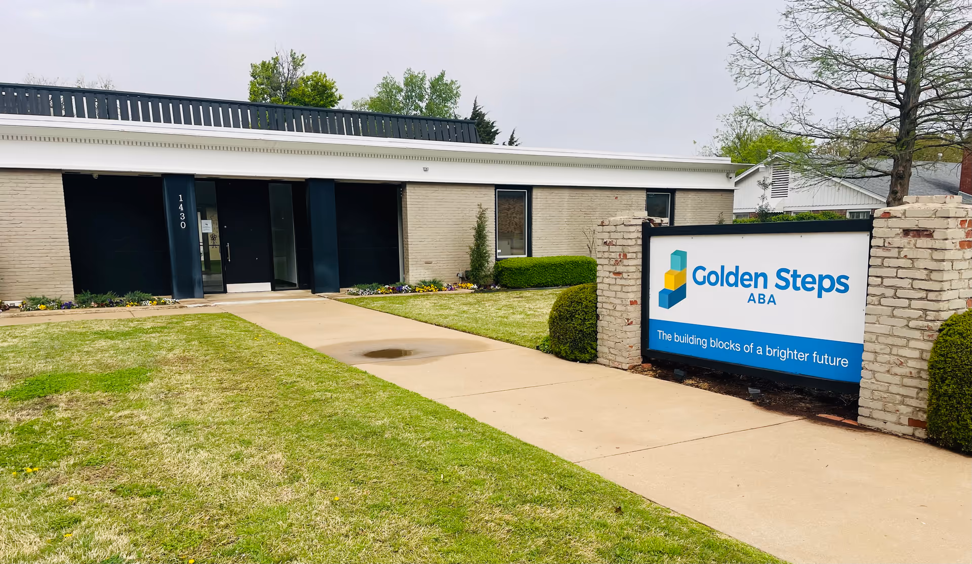 Exterior view of Golden Steps ABA facility with entrance walkway and sign.