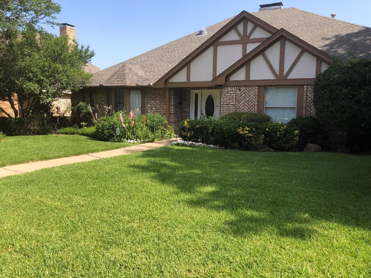 Front view of a single-story brick residential care home with a green lawn.