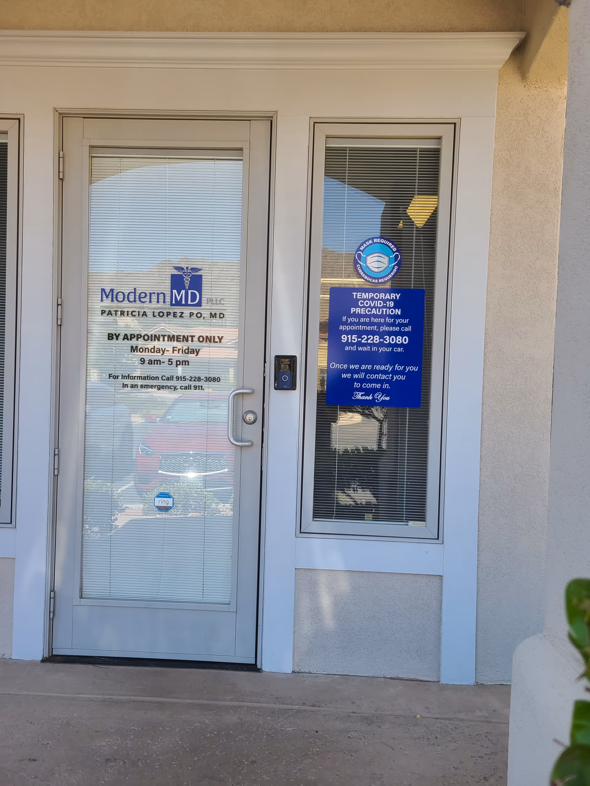 Exterior glass doors show Modern MD clinic signage and a COVID-19 precaution notice.