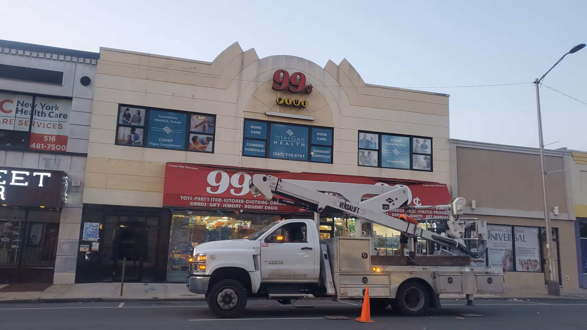 Exterior storefront with Intergen Health signage on a beige building and a utility truck blocking street