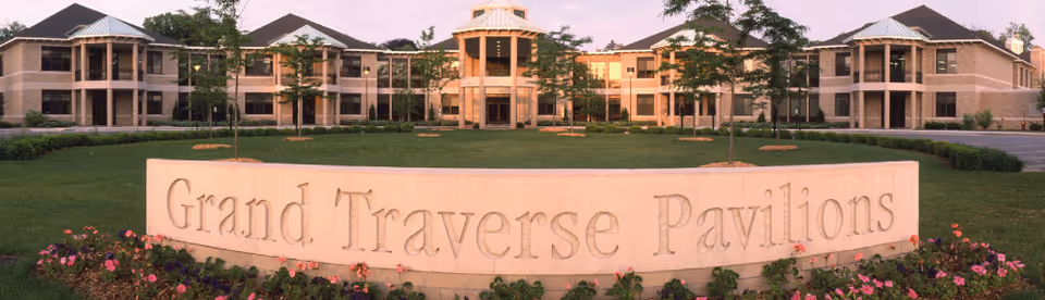 Exterior view of Grand Traverse Pavilions with a stone sign and manicured lawn.
