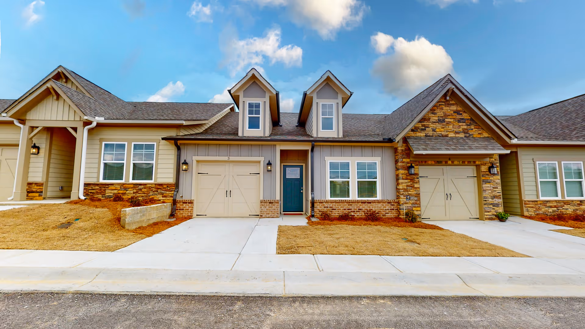 Front exterior view of a modern senior living lodge with garages and stone accents.