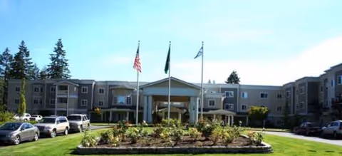 Exterior view of Brookdale Foundation House with front entrance, flags, and landscaped circular garden.