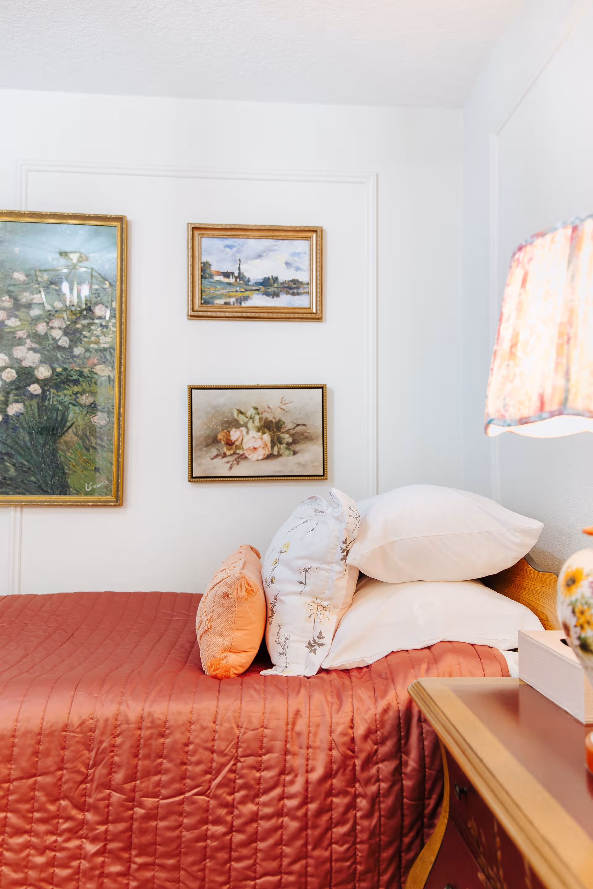 A neatly made bedroom in a senior care facility with a quilted bed and wall art.