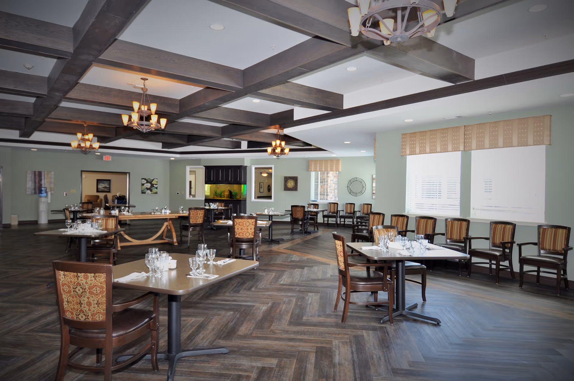 Spacious dining room with multiple tables, chairs, and place settings.