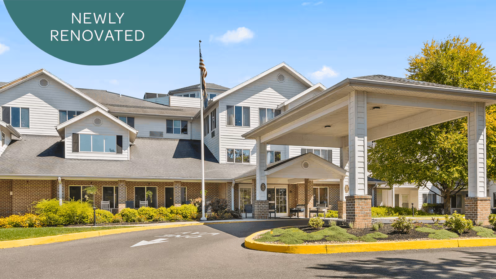 Exterior view of a newly renovated senior living facility with a covered entrance.
