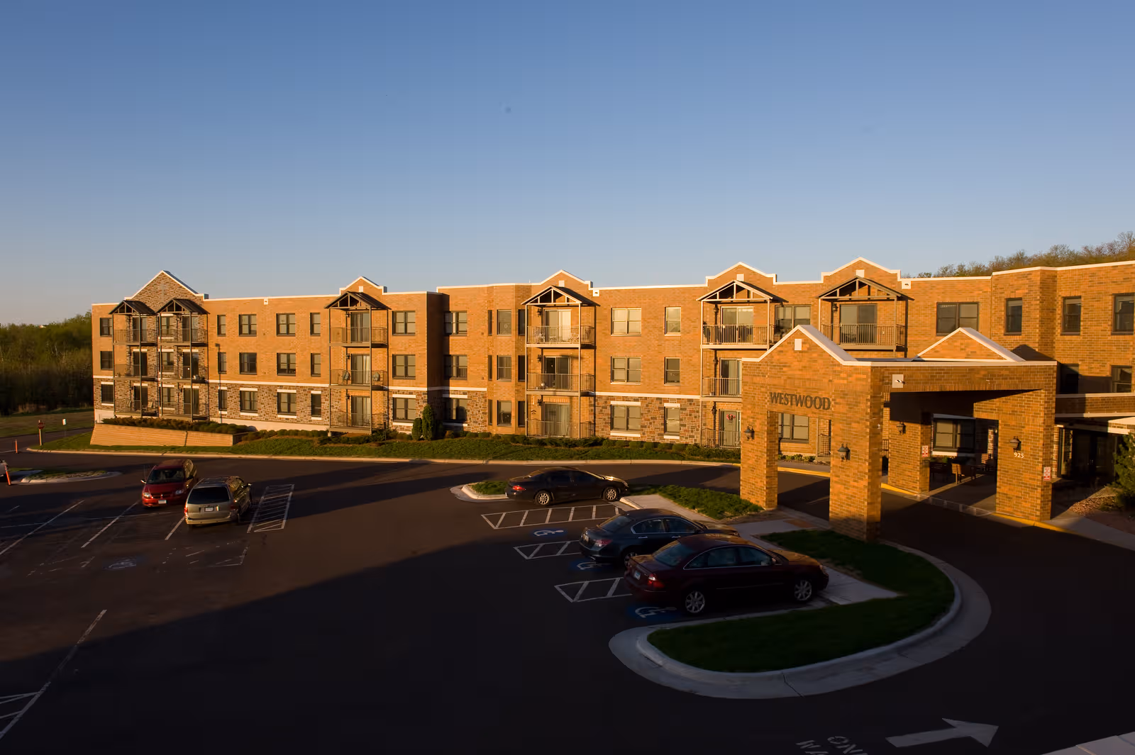 Exterior view of Benedictine Living Community-Duluth building with circular driveway and entry arch.