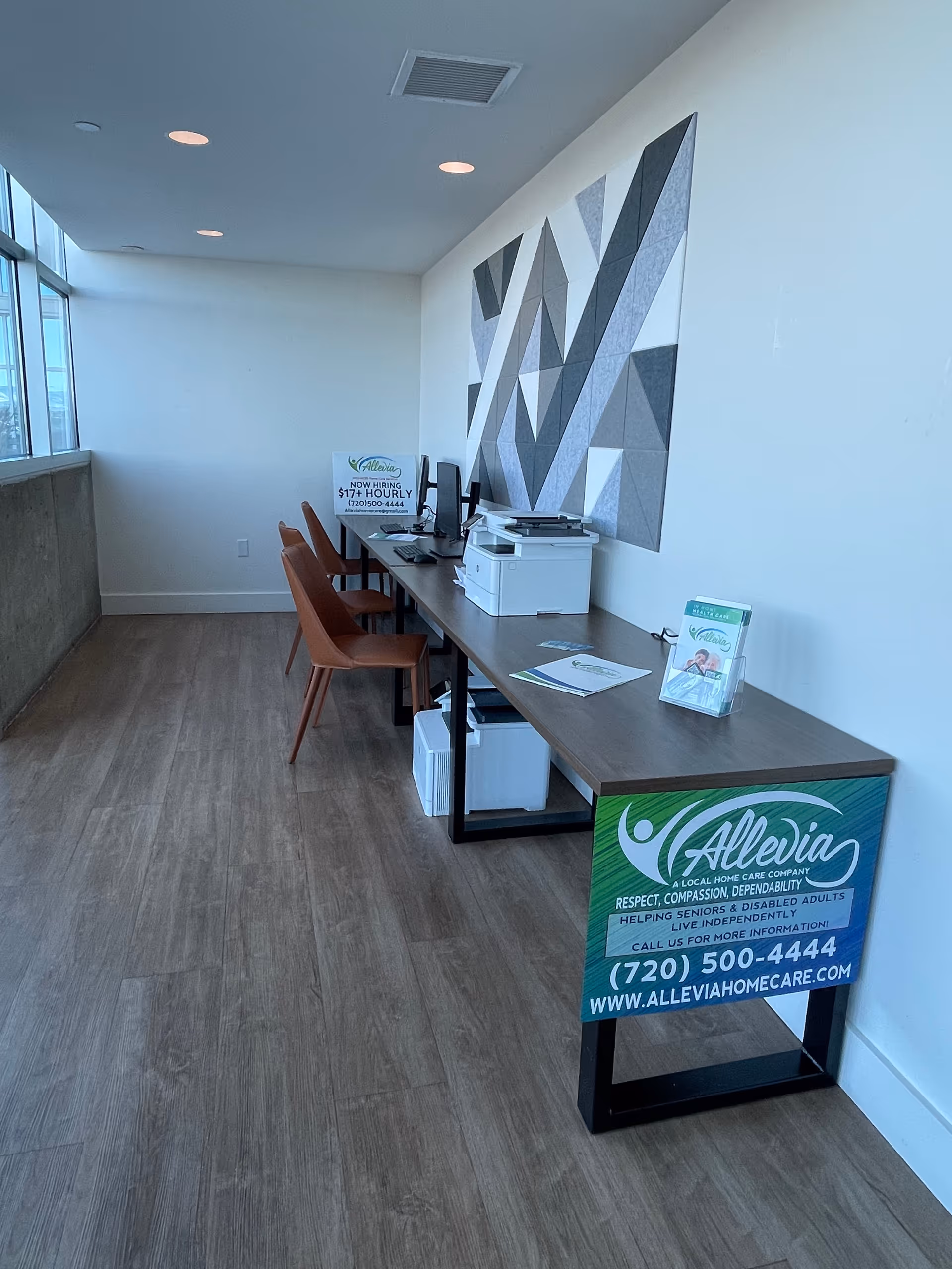 Reception area with a long desk, chairs, printer, and Allevia Home Care signage.