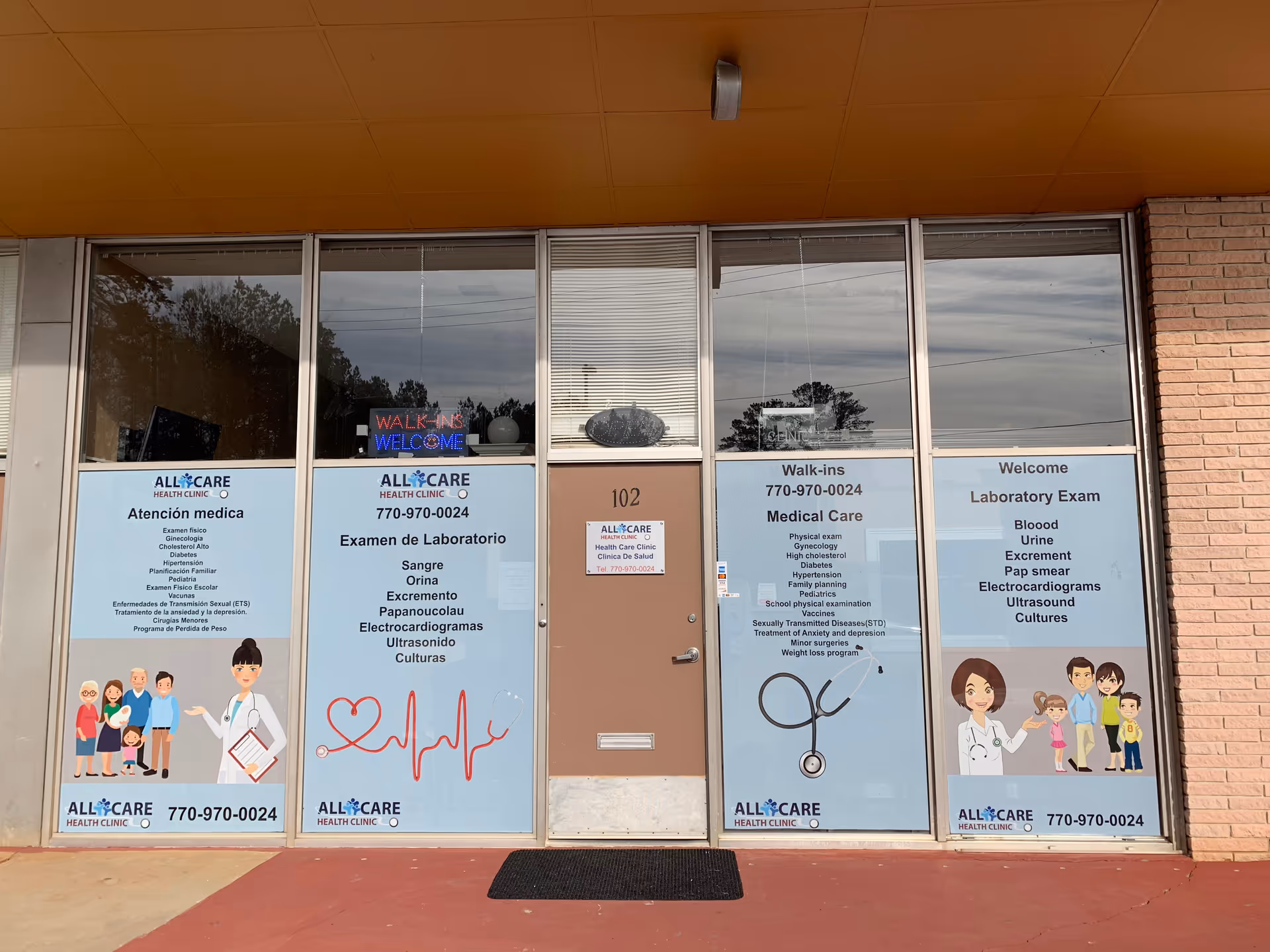 Exterior of a clinic storefront with large window posters and a central door.