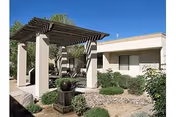 Modern single-story senior living facility exterior with a shaded walkway and desert landscaping.