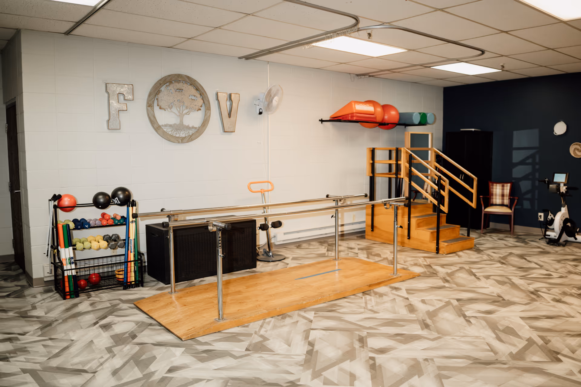 A rehab gym with parallel bars, ramps, and exercise equipment.
