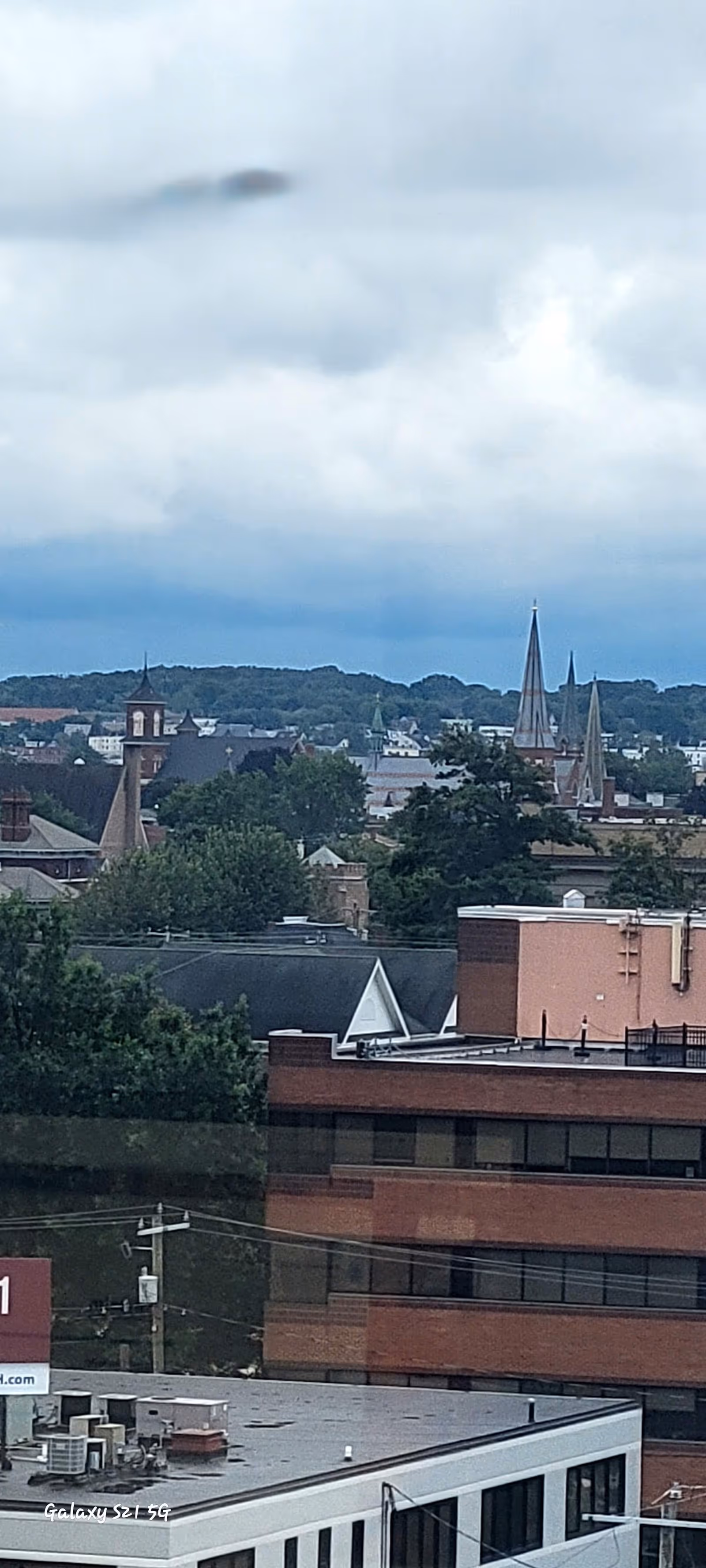 Overcast Manchester cityscape with church steeples and rooftops.